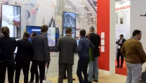 People gathered around BIG PAD interactive displays at ISE