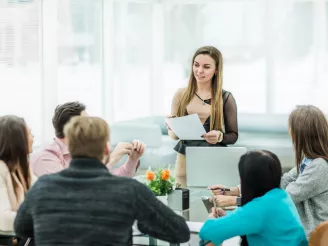 People-sat-around-desk-in-a-meeting