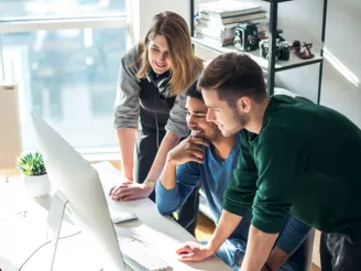 Three colleagues reviewing on-screen content