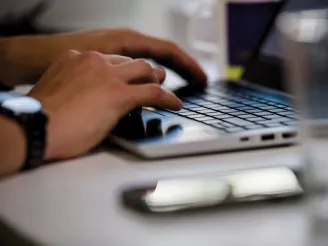 Closeup shot of hands typing on a laptop