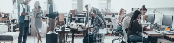 People working at desks and stood around desks