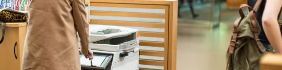 Woman using colour printer in school