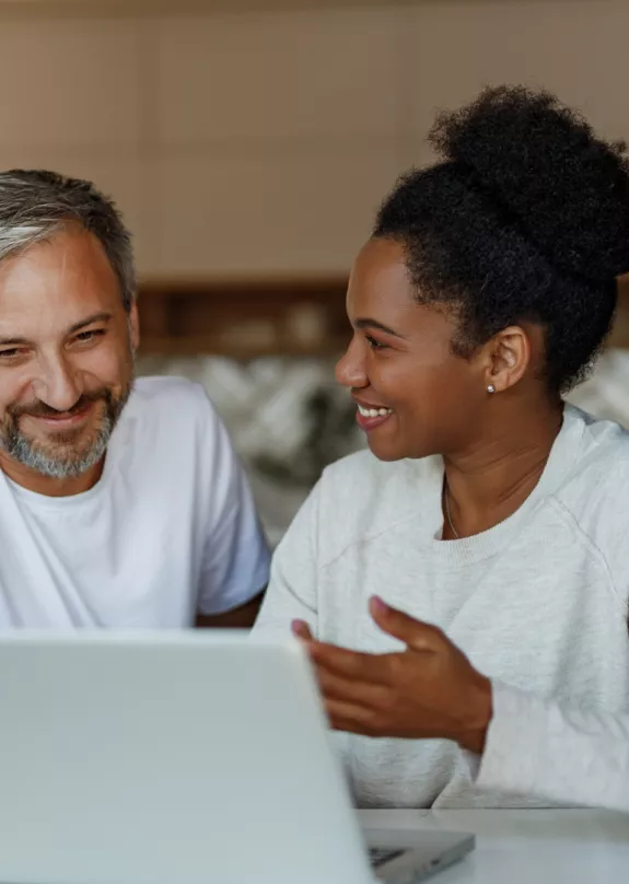 Two people sat at a laptop - discussing cyber security 